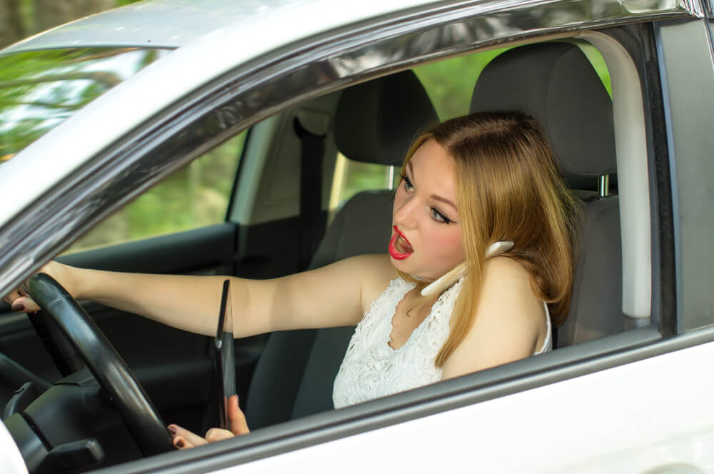 girl working while driving car